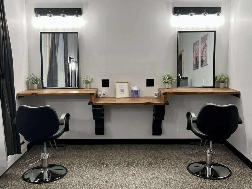 Dressing Suite at The Hidden Abbey with two lighted vanities, styling chairs, and soft, elegant decor.